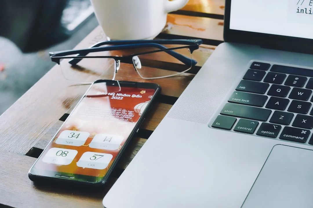 Une personne utilisant un smartphone pour analyser le marché boursier dans un bureau à domicile.